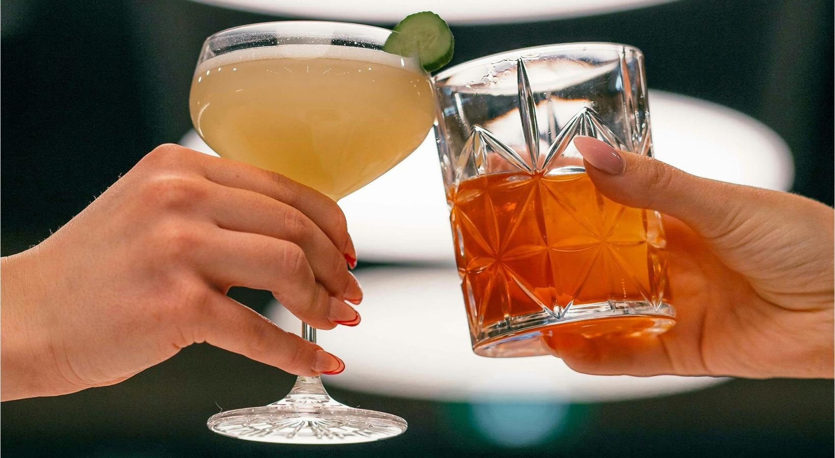 hands holding glasses with cocktails