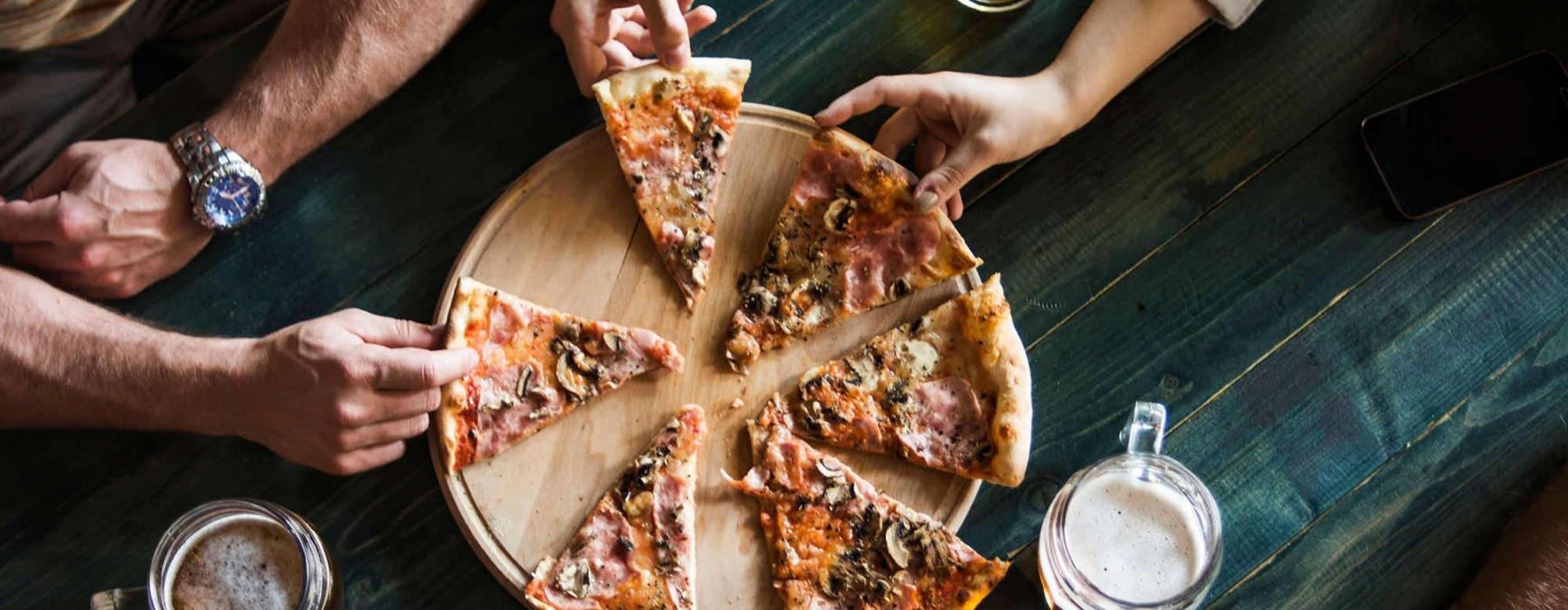 a group of people eating pizza