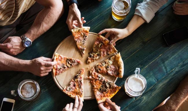 a group of people eating pizza